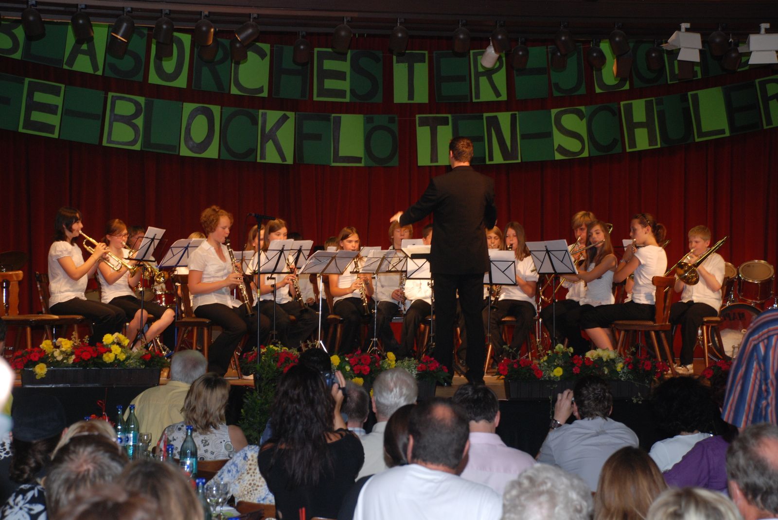 Das Jugendblasorchester TSV Braunshardt beim Jugendmusiktag 2009 auf der Bühne: rund 15 Jugendliche in weißen Hemden mit Trompeten, Klarinetten, Saxophonen und Posaune, vorne der Dirigent, davor das Publikum