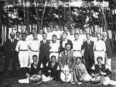 Gruppenbild des Spielmannszugs TSV Braunshardt 1924: rund zwanzig junge Männer in weißen Hemden, vorne sitzend vier Trommler mit ihren Trommeln